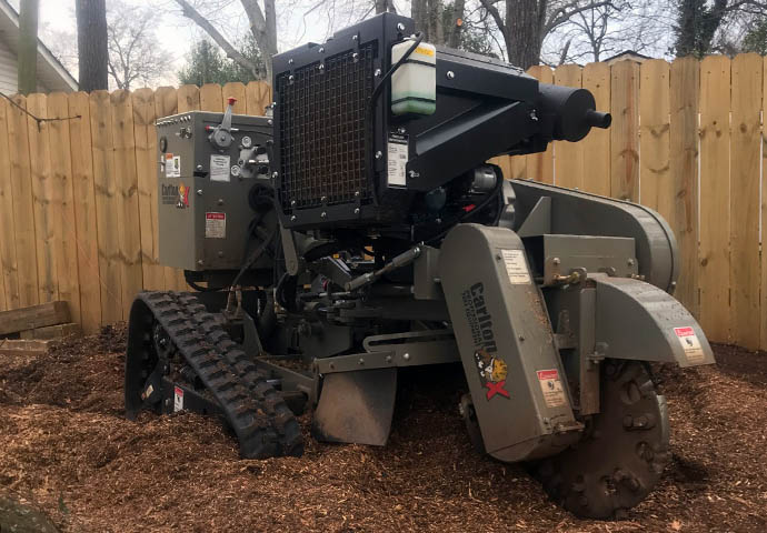 A stump grinder grinding down a stump, wood chips are flying!